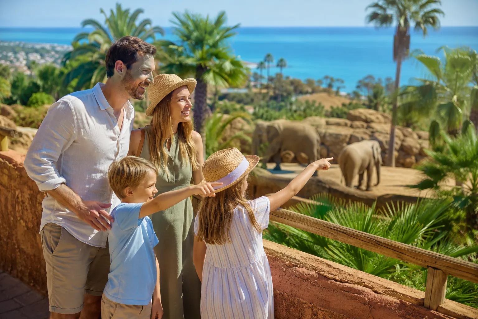 Editorial () hero image, no text overlays. A joyful German family with two young children standing at the entrance of a